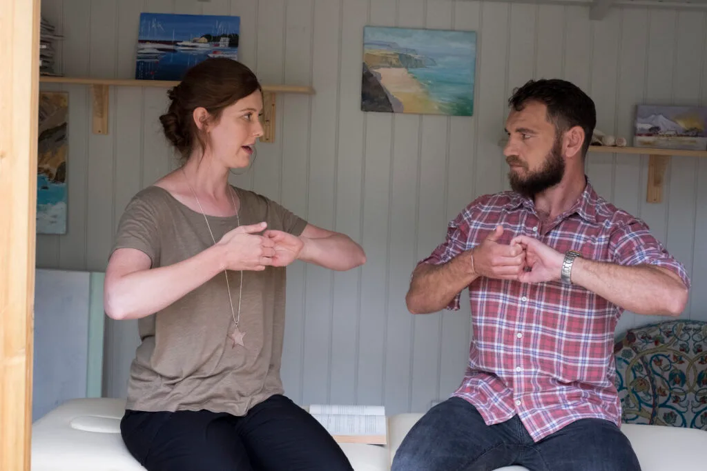 Alternative therapies,United Kingdom,Man and female therapist with their hands clasped gripping the curled fingers. sign language translator translate to asl language sign translator sign language interpreter